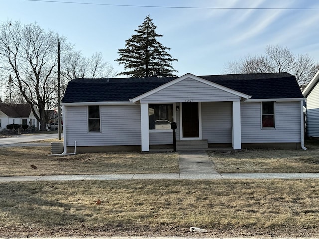 view of front of home featuring a porch, central AC unit, and a front lawn