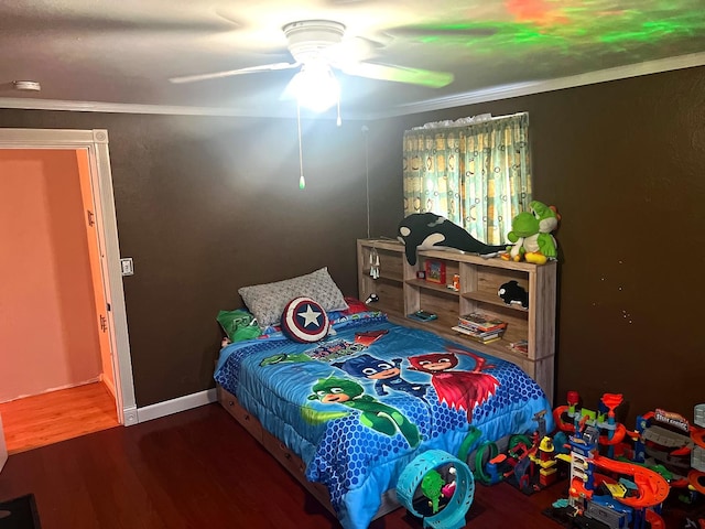 bedroom featuring dark hardwood / wood-style flooring, ceiling fan, and ornamental molding