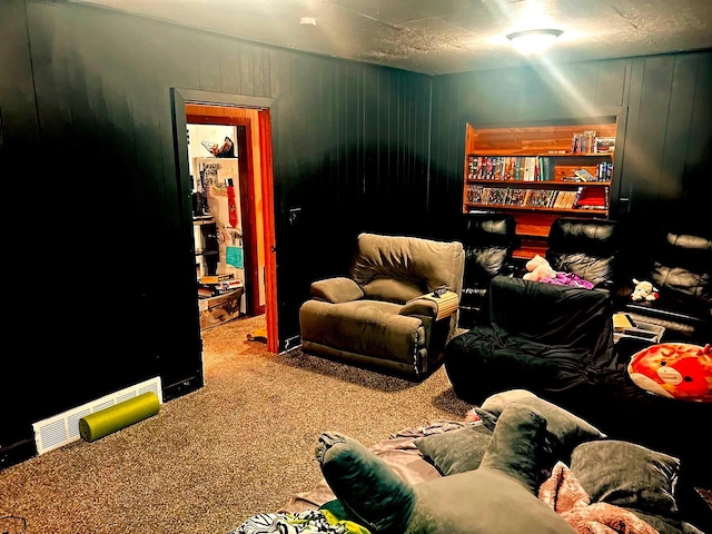 carpeted home theater room featuring wood walls