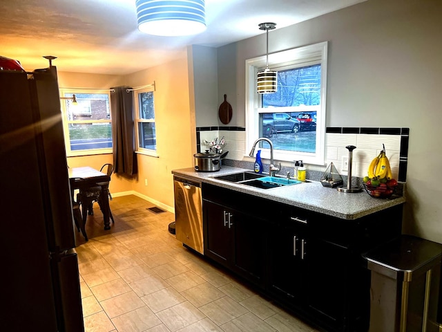 kitchen with stainless steel dishwasher, sink, hanging light fixtures, and fridge