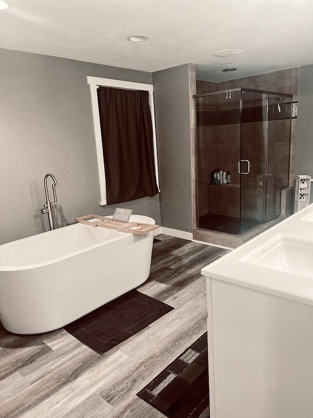 bathroom with separate shower and tub, hardwood / wood-style floors, and sink