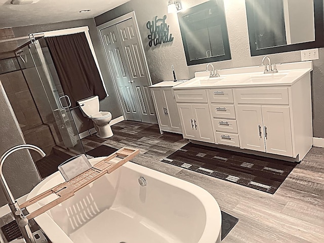 full bathroom featuring hardwood / wood-style floors, vanity, shower with separate bathtub, and toilet