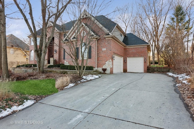 view of front of house featuring a garage, roof with shingles, concrete driveway, and brick siding