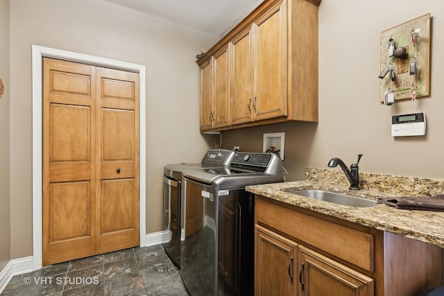 laundry area with independent washer and dryer, a sink, cabinet space, and baseboards