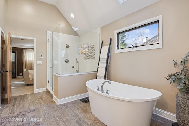 ensuite bathroom featuring baseboards, a soaking tub, wood finished floors, vaulted ceiling, and a shower stall