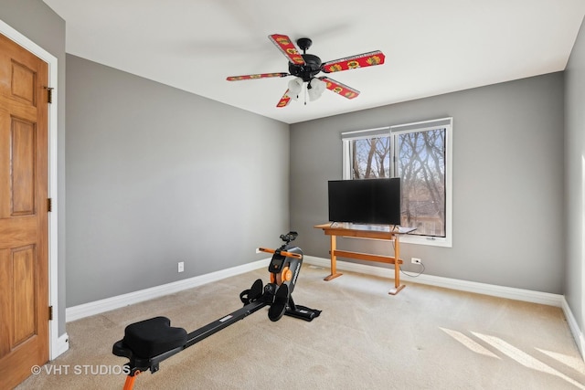 exercise room with a ceiling fan, baseboards, and carpet flooring