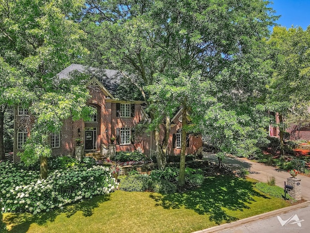 view of front of home with brick siding and a front lawn