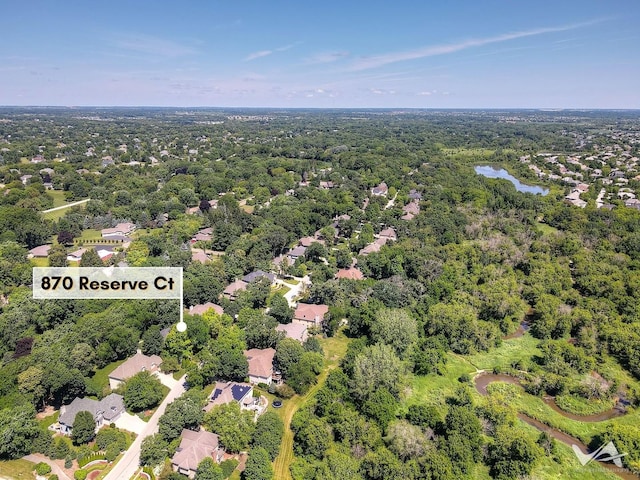 birds eye view of property featuring a water view and a wooded view