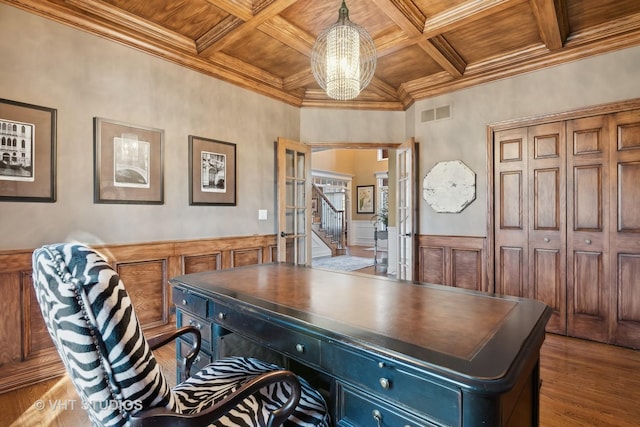 office space with wooden ceiling, coffered ceiling, wood finished floors, ornamental molding, and beamed ceiling