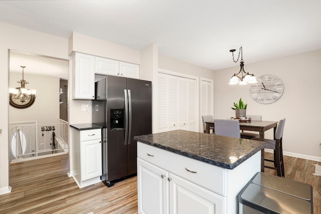 kitchen with white cabinets, a center island, stainless steel fridge with ice dispenser, and a notable chandelier