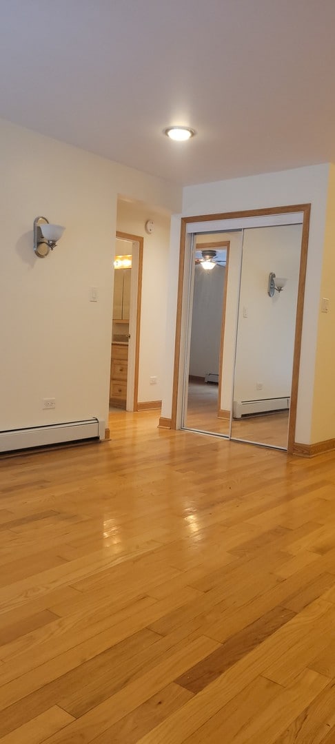 unfurnished room featuring light hardwood / wood-style flooring and a baseboard radiator