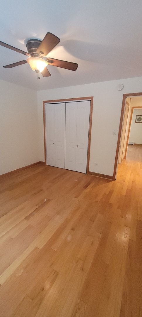 unfurnished bedroom with ceiling fan, light hardwood / wood-style floors, and a closet