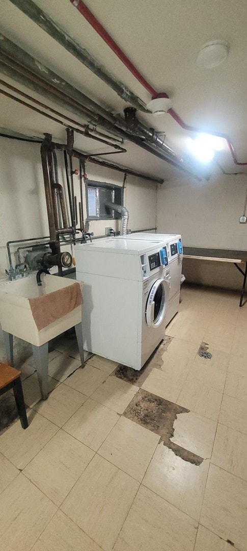 washroom with washing machine and clothes dryer and sink