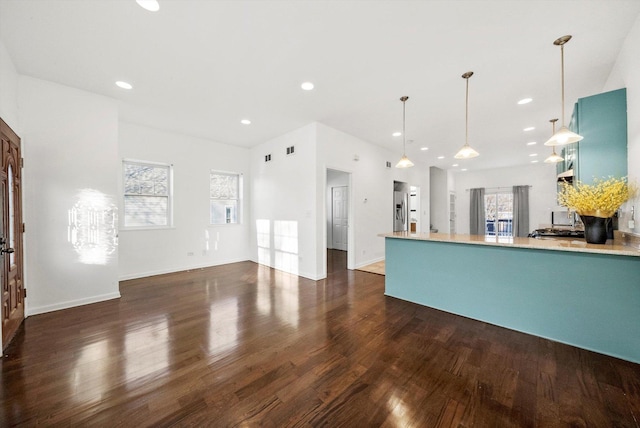 kitchen with stainless steel fridge, decorative light fixtures, and dark wood-type flooring