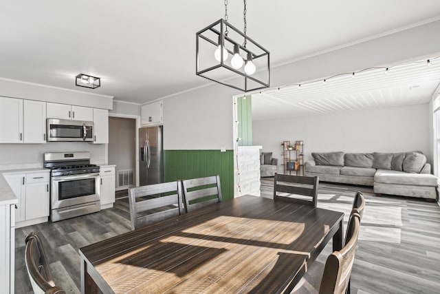 dining area with a notable chandelier, dark hardwood / wood-style flooring, and crown molding