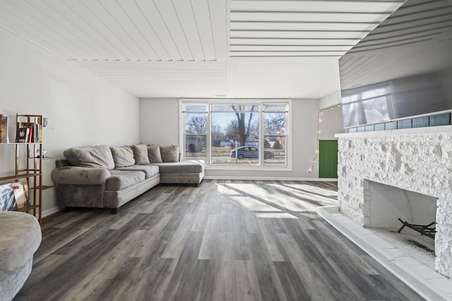 living room with a fireplace and dark wood-type flooring