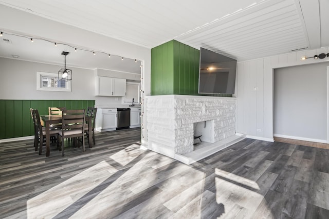 living room featuring dark hardwood / wood-style flooring, wooden walls, and sink