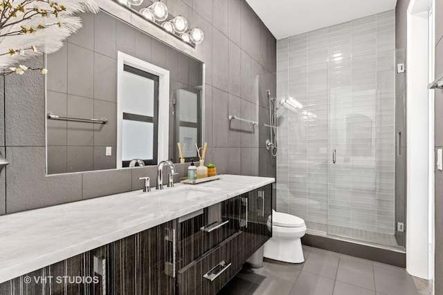 bathroom with tile patterned flooring, vanity, tile walls, and toilet