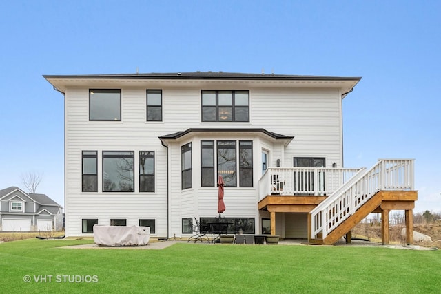 rear view of house featuring a lawn and a deck