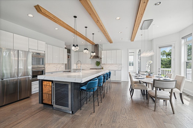 kitchen with white cabinetry, a large island, decorative light fixtures, and appliances with stainless steel finishes