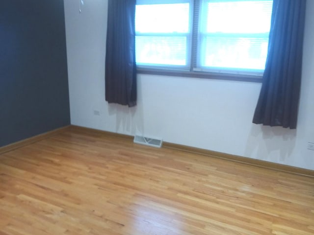 unfurnished room featuring plenty of natural light and light hardwood / wood-style floors