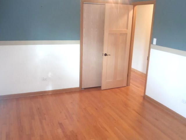 unfurnished bedroom with light hardwood / wood-style flooring and a closet