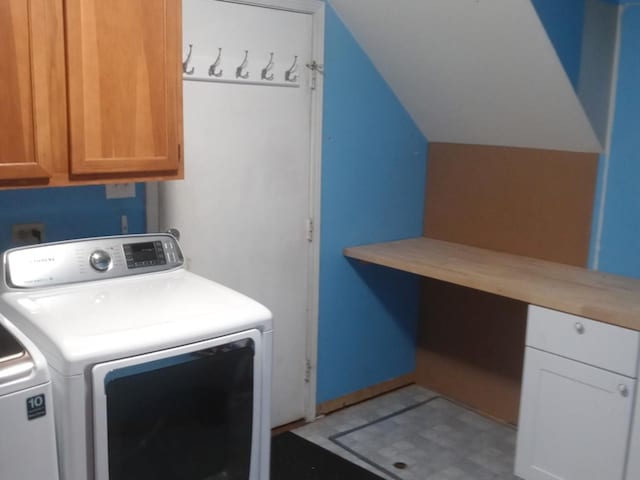 clothes washing area featuring cabinets and washing machine and dryer