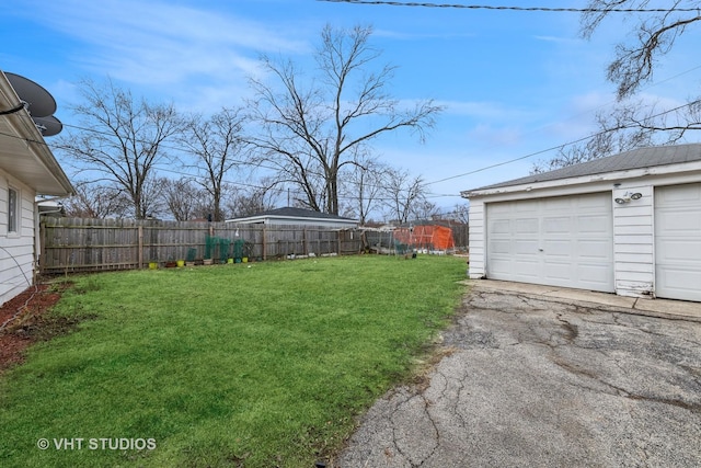 view of yard featuring a garage, fence, and an outdoor structure