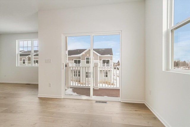 interior space featuring light wood-style floors, visible vents, and baseboards