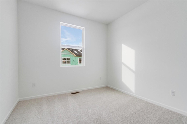 carpeted empty room with visible vents and baseboards