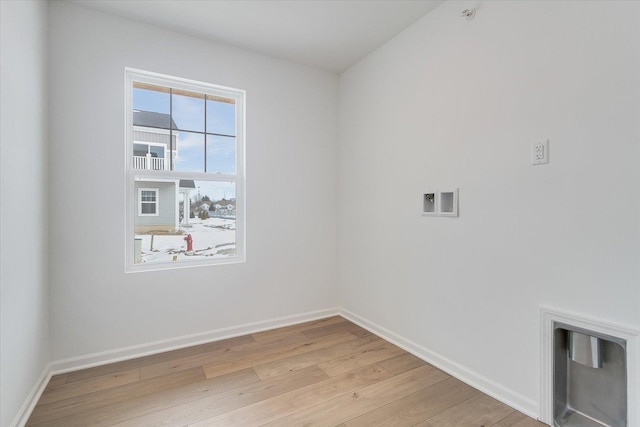 clothes washing area featuring laundry area, light wood-style flooring, and baseboards