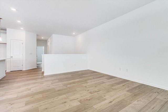 empty room featuring light wood-style floors, recessed lighting, and baseboards