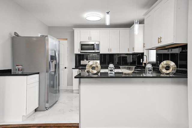 kitchen featuring white cabinets, sink, appliances with stainless steel finishes, decorative light fixtures, and kitchen peninsula