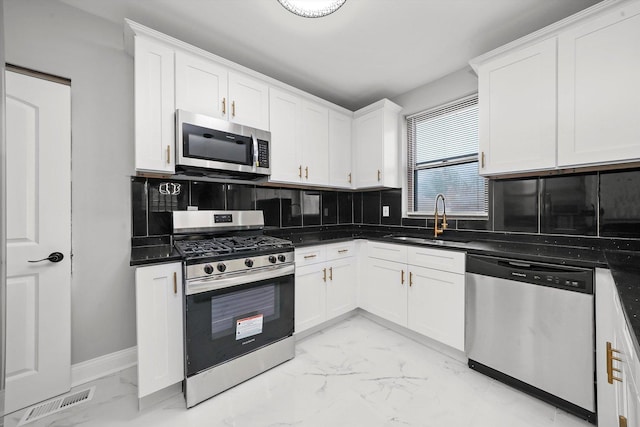 kitchen featuring white cabinets, stainless steel appliances, tasteful backsplash, and sink