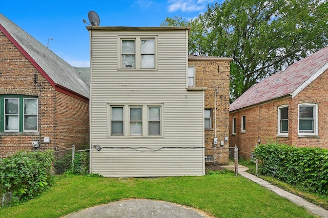 back of house with a lawn