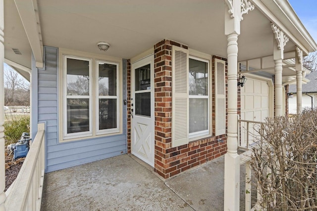 view of exterior entry with covered porch and a garage