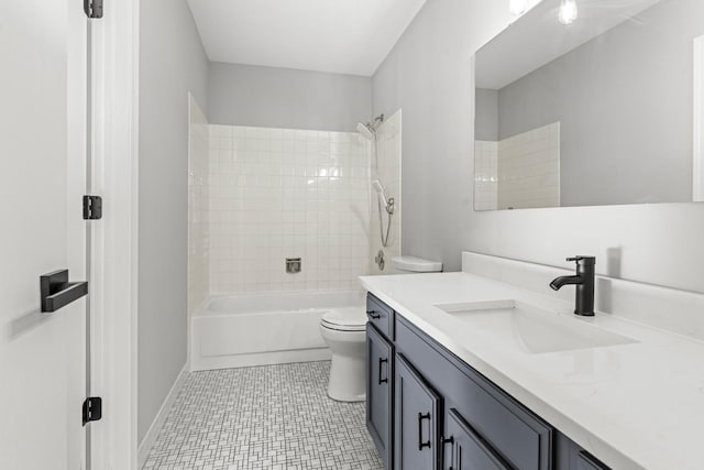 full bathroom featuring vanity, tiled shower / bath, and toilet