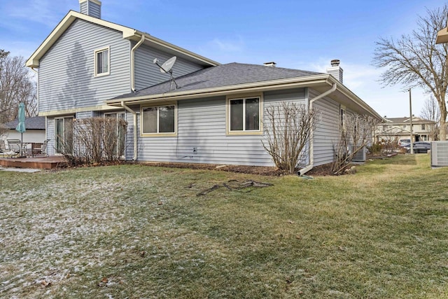 rear view of property with a yard, a wooden deck, and central air condition unit