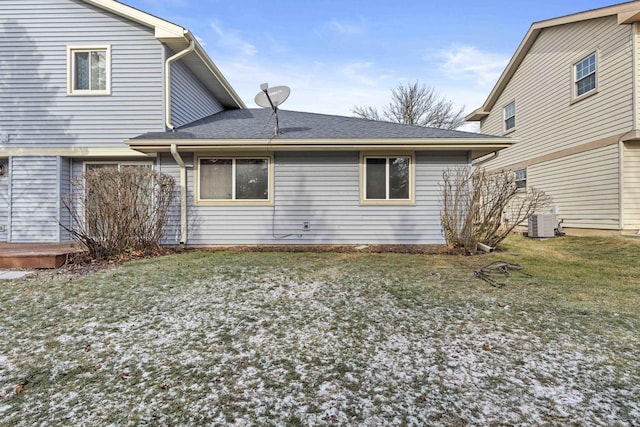 rear view of property with central air condition unit, a wooden deck, and a lawn