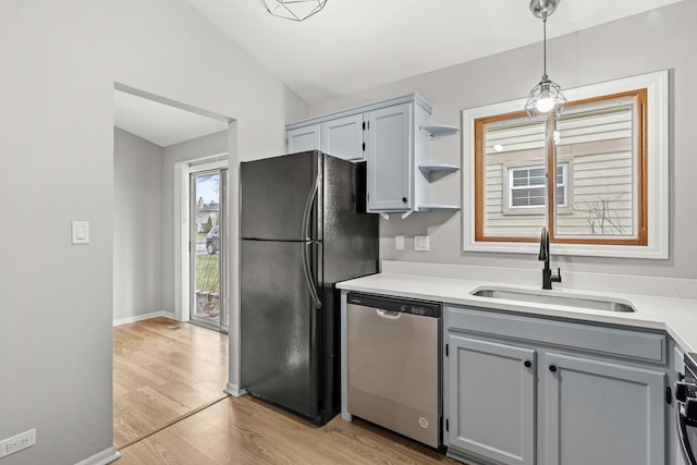 kitchen with pendant lighting, lofted ceiling, refrigerator, sink, and stainless steel dishwasher