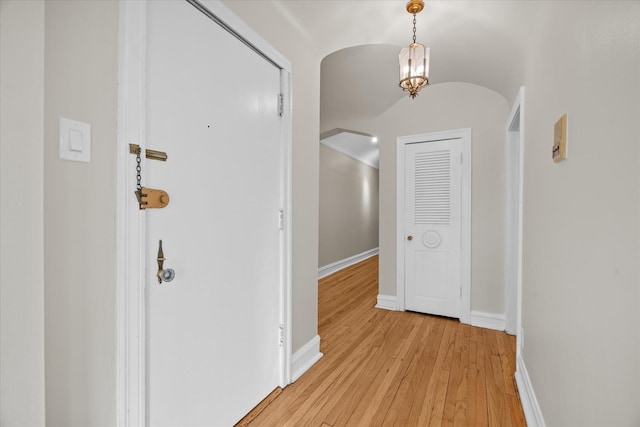 corridor featuring an inviting chandelier and light hardwood / wood-style floors