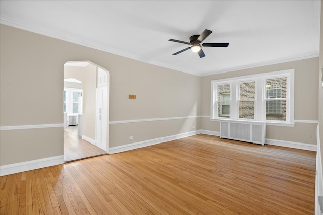 unfurnished room with crown molding, ceiling fan, radiator heating unit, and light wood-type flooring