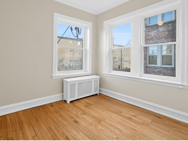 interior space with radiator heating unit and light wood-type flooring