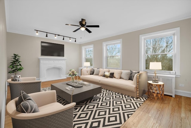 living room with ceiling fan, ornamental molding, radiator heating unit, and dark hardwood / wood-style floors