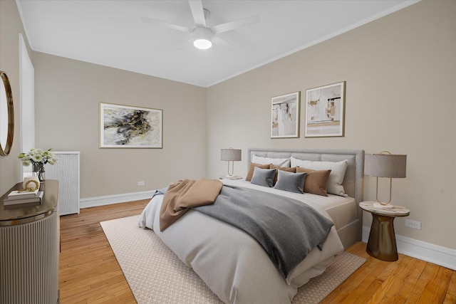 bedroom featuring ceiling fan, ornamental molding, and light hardwood / wood-style flooring