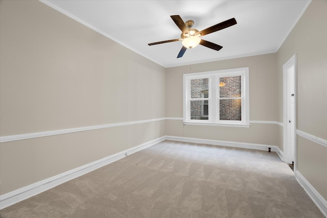 spare room featuring light carpet, ornamental molding, and ceiling fan