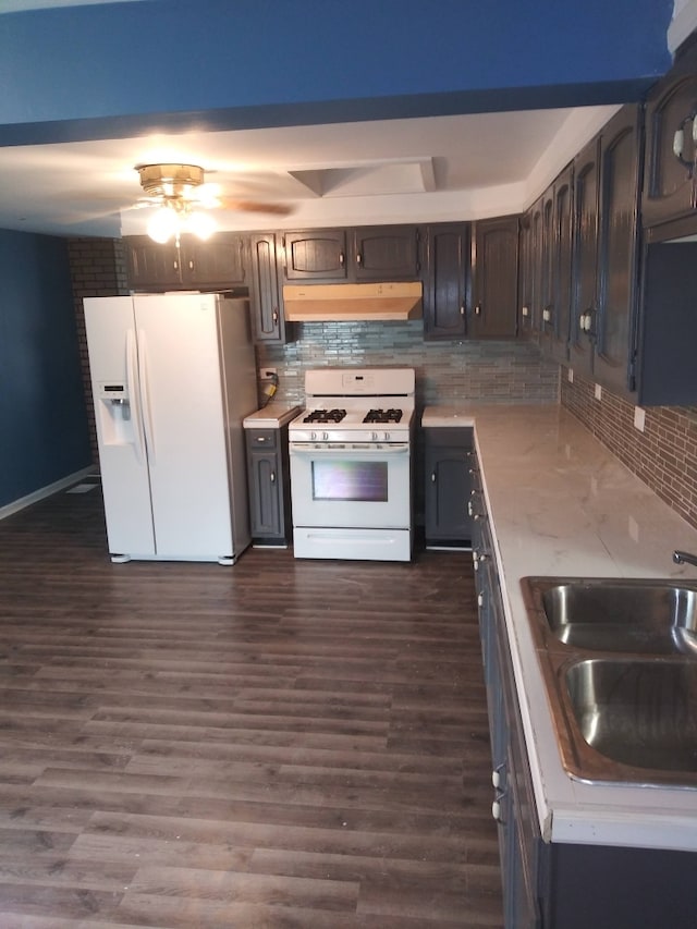 kitchen featuring backsplash, dark hardwood / wood-style flooring, white appliances, and sink