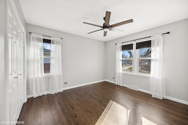 unfurnished room with ceiling fan and dark wood-type flooring