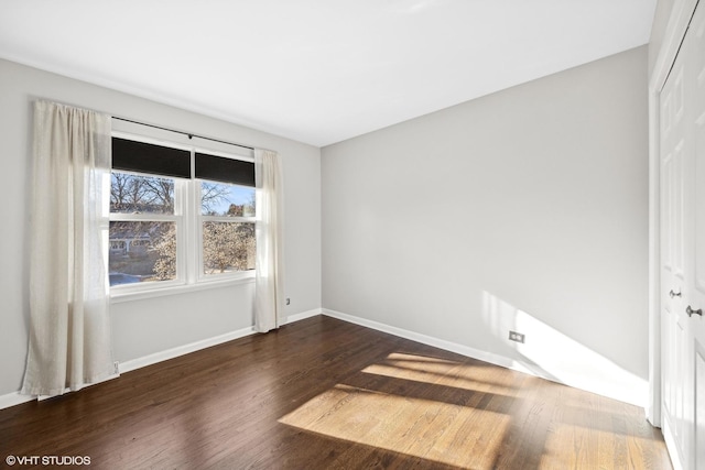 unfurnished room featuring dark wood-type flooring