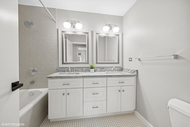 full bathroom featuring tiled shower / bath combo, toilet, and vanity